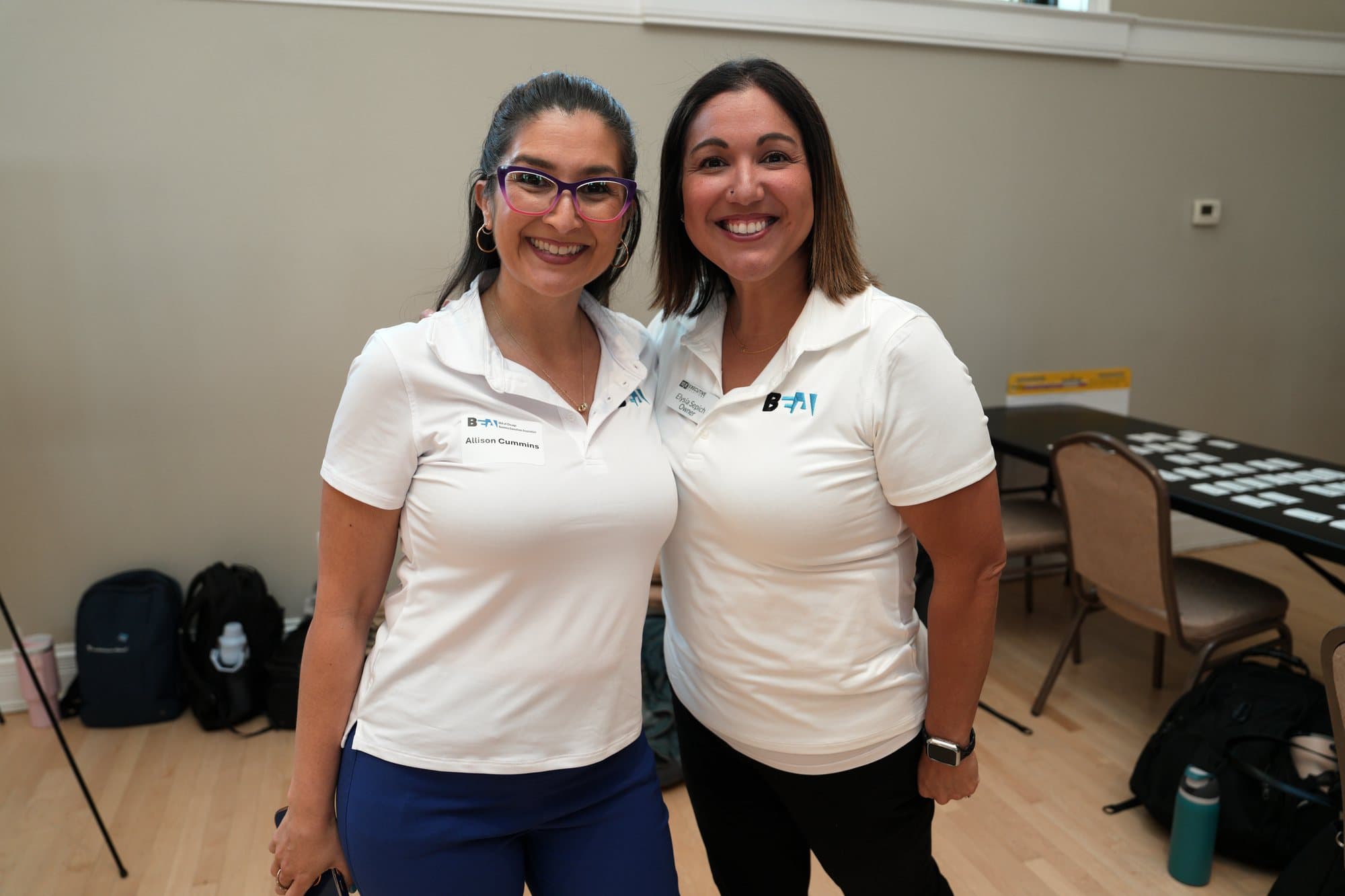 Two members in white BEA polos at an association event