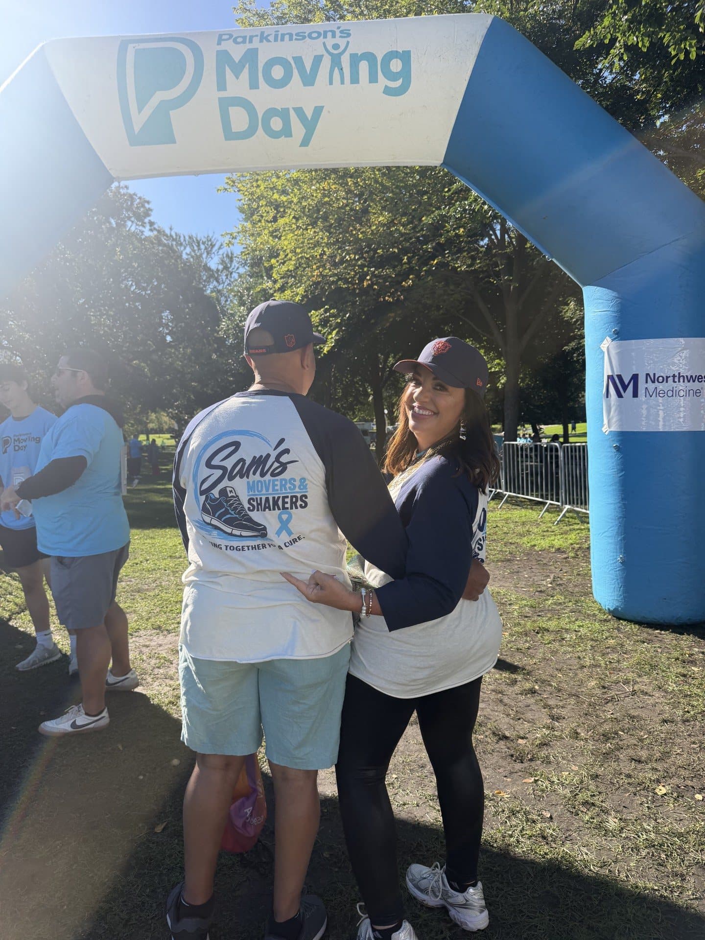 Two volunteers at Parkinson's Moving Day, showing the back of the Sam's Movers and Shakers tee