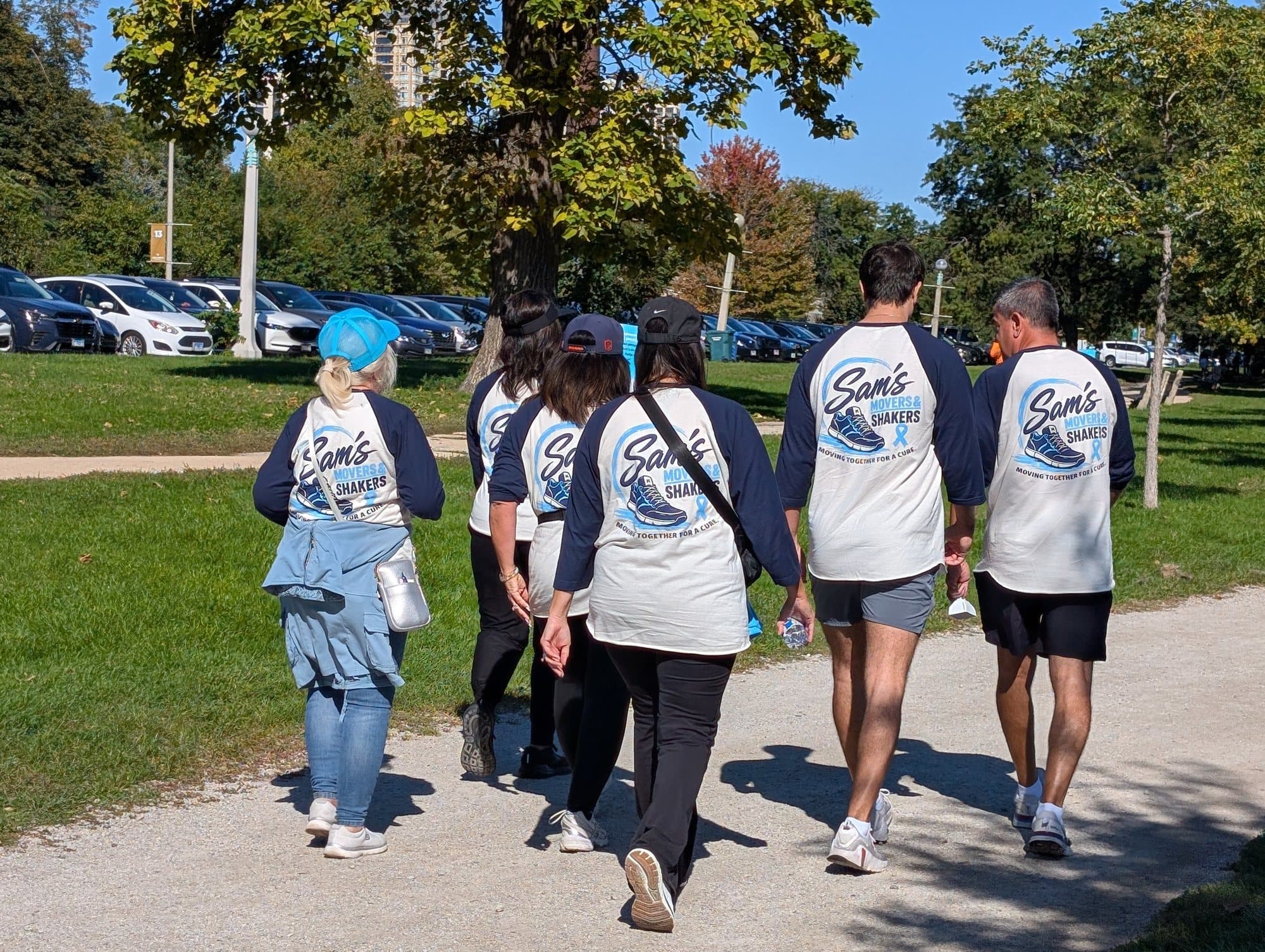 Volunteers walking in Sam's Movers and Shakers raglan tees, seen from behind