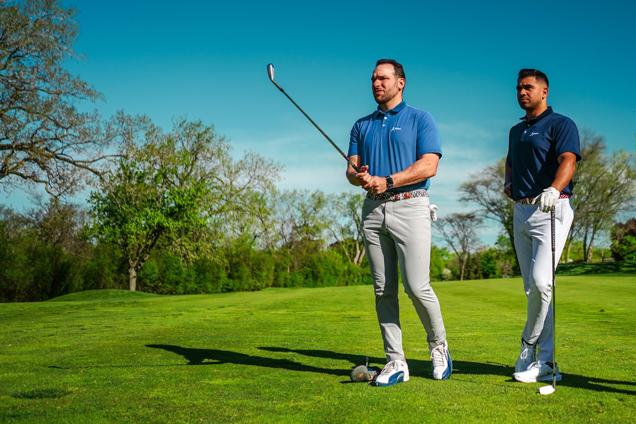 Two golfers in Pichón polos on the tee